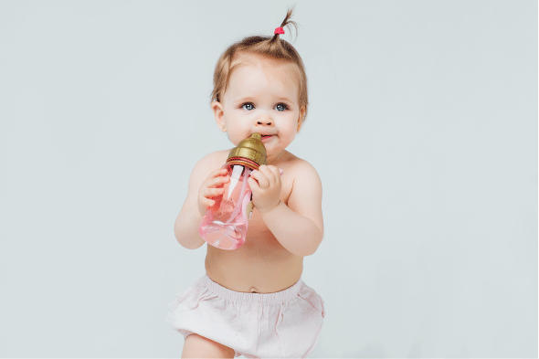 happy-girl-diaper-with-cute-hairstyle-holds-bottle-milk.png